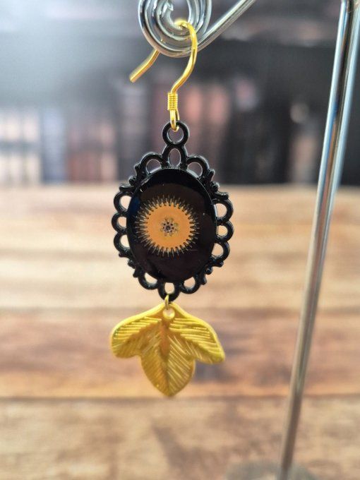 Boucles d'oreilles noires avec des breloques feuilles dorées  